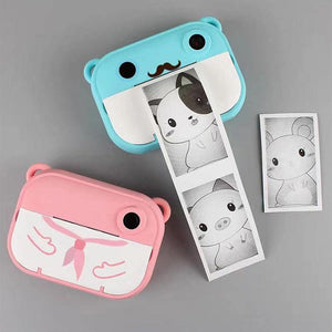 Cute kids instant print cameras in blue and pink with black and white photo strips featuring animal illustrations
